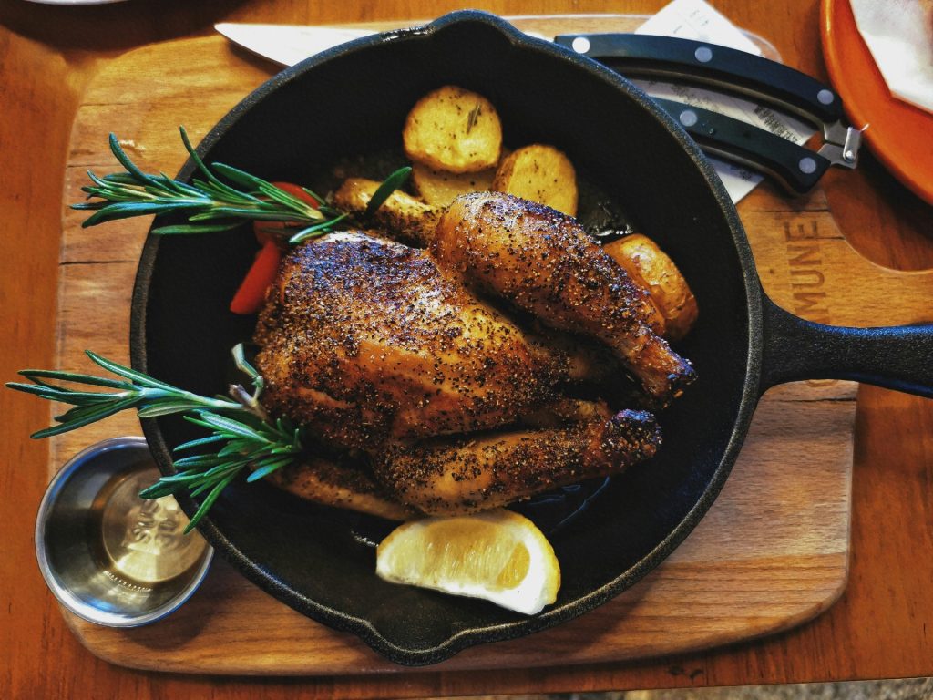Gegrilltes Fleisch auf einem schwarzen runden Teller
